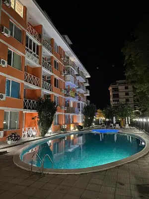 a swimming pool in front of a building at night at Gerber Residence 2 in Sunny Beach