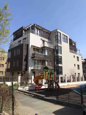 a apartment building with a playground in front of it at Апартамент Хармония in Sozopol