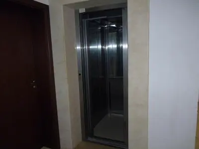 a glass shower in a room with a wall at Апартамент Хармония in Sozopol