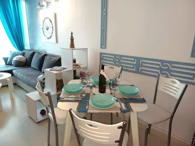 a dining table and chairs in a living room at Апартамент BLUE SUMMER - уют, близо до морето in Burgas City