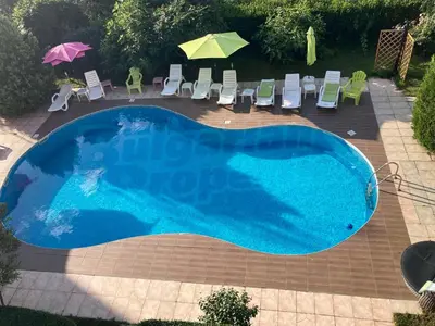 a large blue pool with chairs and umbrellas at Sunny Gardens in Sunny Beach