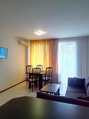 a living room with a couch and a table and chairs at Sunny Gardens in Sunny Beach