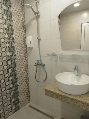 a bathroom with a sink and a shower with a mirror at Санта Марина in Varna City
