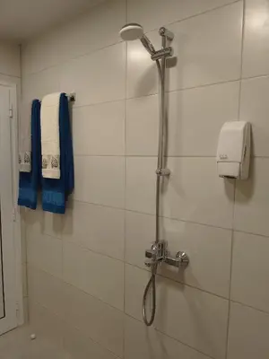 a shower in a bathroom with a blue towel at Санта Марина in Varna City