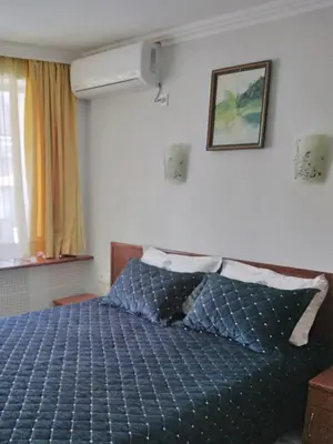 a bedroom with a bed with a blue comforter at Санта Марина in Varna City