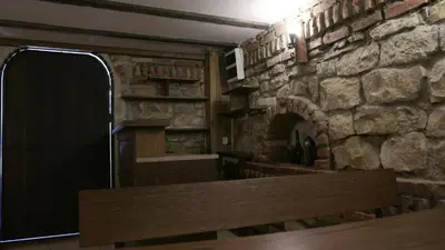a kitchen with a stone wall and a wooden door at Къща за гости АЛЛА in Byala