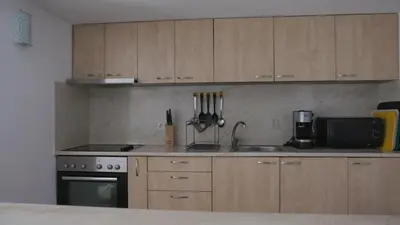 a kitchen with a sink and a stove and cabinets at Къща за гости АЛЛА in Byala