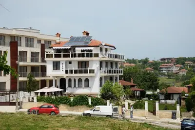 a large white house with solar panels on its roof at Къща за гости АЛЛА in Byala