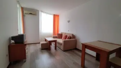 a living room with a couch and a table at Апартамент Полюси 2 in Sunny Beach