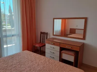a bedroom with a dresser with a mirror and a bed at Апартамент Полюси 2 in Sunny Beach