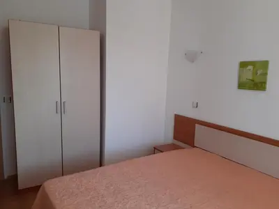 a bedroom with a bed and white cabinets at Апартамент Полюси 2 in Sunny Beach