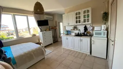 a kitchen with white cabinets and a bed in a room at Studio Seaven, Lozenets in Lozenets
