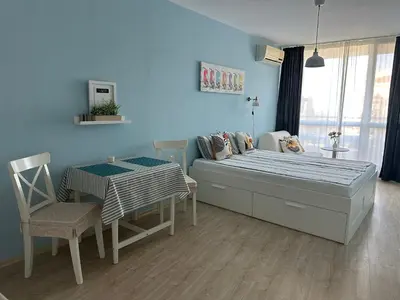 a bedroom with a bed and a table and chairs at Studio B28 Sunny Island Chernomorez in Chernomorets