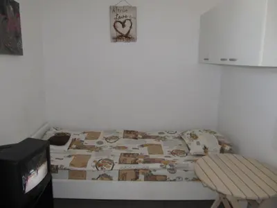 a small bedroom with a bed and a tv at Apartments and studios in Cote d’Azure in Sunny Beach