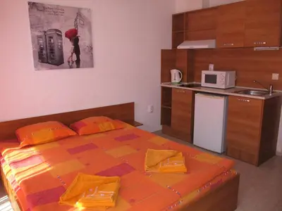 a small bedroom with a bed and a microwave at Apartments and studios in Cote d’Azure in Sunny Beach