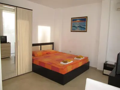 a bedroom with a bed with orange pillows at Apartments and studios in Cote d’Azure in Sunny Beach