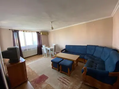 a living room with a blue couch and a table at Апартамент 