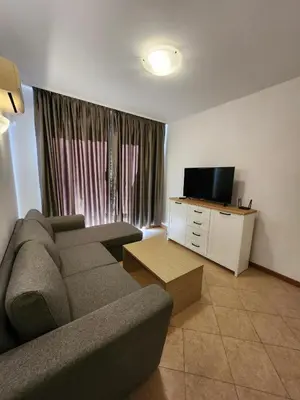 a living room with a couch and a television at One bedroom guest suite in Sunny Beach
