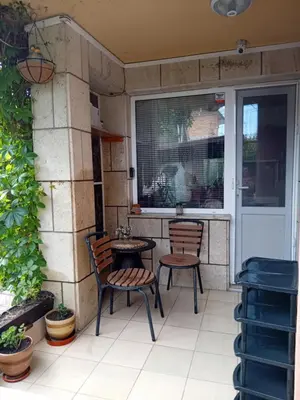 a patio with two chairs and a table and a window at къща за гости Градина in Aheloy