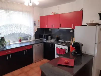 a kitchen with red cabinets and a white refrigerator at къща за гости Градина in Aheloy