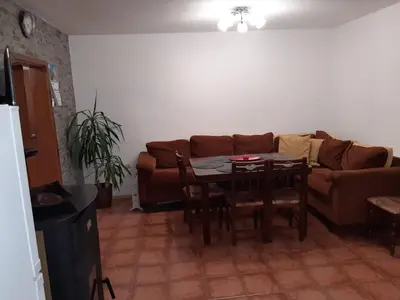 a living room with a table and a couch at къща за гости Градина in Aheloy