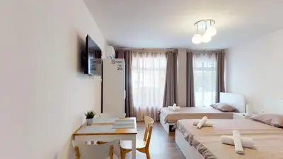 a hotel room with two beds and a table and chairs at Markoni 4 in Burgas City