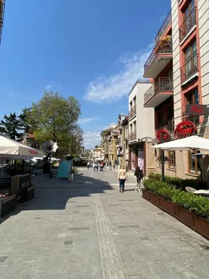 a person walking down a street in a city at Markoni 4 in Burgas City