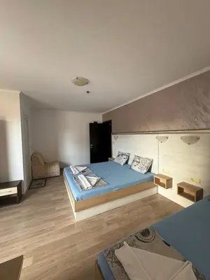a bedroom with a blue bed in a room at Къща за гости Деневи in Primorsko