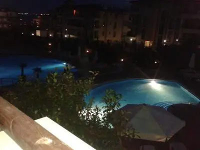 a view of a pool at night with an umbrella at Александър Студио in Sveti Vlas