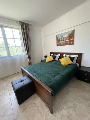 a bedroom with a large green bed with yellow pillows at Apartament in The Cliff Beach & Spa **** in Obzor