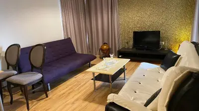 a living room with a purple couch and a tv at Sozopol Apartcomplex Onegin 2,free parking in Sozopol