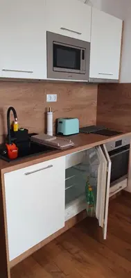 a kitchen with a counter with a microwave and a stove at Smokini Beach Apartment in Sozopol