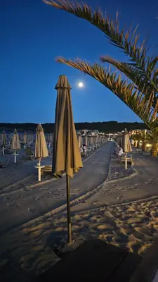 a group of umbrellas and chairs on a beach at Smokini Beach Apartment in Sozopol