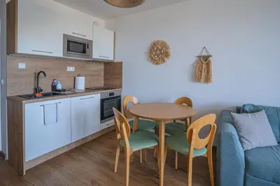 a kitchen and a table and chairs in a room at Smokini Beach Apartment in Sozopol