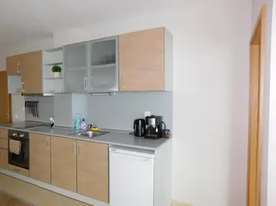 a kitchen with stainless steel appliances and wooden cabinets at Apartment Sunrise Pomorie in Pomorie