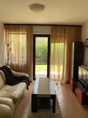 a living room with a couch and a tv and a table at Апартамент Silver Star in Sozopol