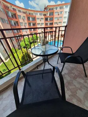 a table and chairs on a balcony with a view of a building at Apartmán TTT in Burgas City