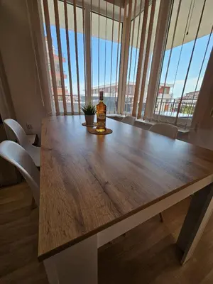 a bottle of whisky sitting on a wooden table with a window at Apartmán TTT in Burgas City