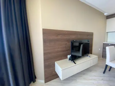 a living room with a tv on a white cabinet at PARADISO 'B' 605 Private Apartment Nessebar in Nesebar
