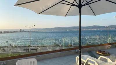 a patio with a view of the water and an umbrella at PARADISO 'B' 605 Private Apartment Nessebar in Nesebar
