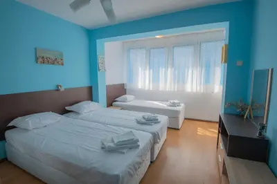 a bedroom with two beds and a blue wall at One-bedroom Flat Close to the Sea Garden by Flat Mаnаger in Burgas City