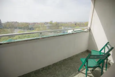 a balcony with a green chair and a window at One-bedroom Flat Close to the Sea Garden by Flat Mаnаger in Burgas City