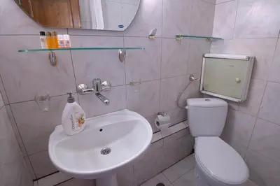 a bathroom with a white sink and a toilet at One-bedroom Flat Close to the Sea Garden by Flat Mаnаger in Burgas City