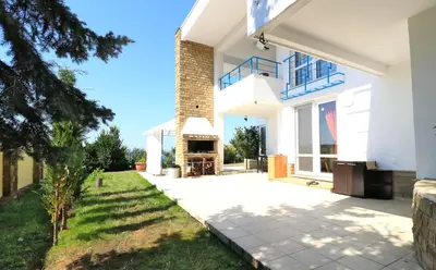 a house with a fireplace in a yard at Ravda Residence in Ravda