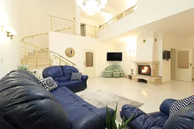 a living room with blue couches and a fireplace at Ravda Residence in Ravda
