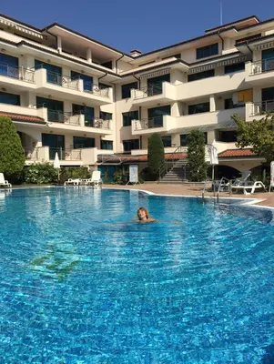a woman swimming in a swimming pool in a hotel at Cozy 1 bed apartment in Lesso Complex (Ravda, Nessebar) in Ravda