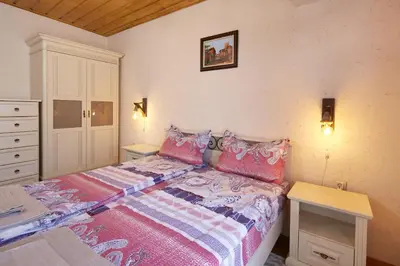 a bedroom with a bed with pink and purple sheets at ВИЛА ТЪРТЕФФ in Nesebar
