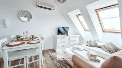 a white living room with a table and a couch at BohoTide by the Sea in Bliznatsi