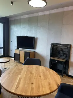 a room with a table and a television and a piano at Sea Scenery Apartment in Burgas City