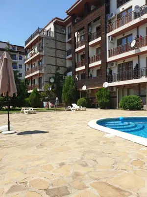 a large apartment building with a swimming pool and an umbrella at MitProt Panorama Bay 2 ap 31 in Sveti Vlas
